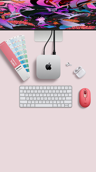 Mac mini, top, silver aluminum, rounded corners, glossy black Apple logo centered, connected by cord, Studio Display partially visible on top, AirPod 4, open, Pantone color swatches, and red Logitech keyboard and mouse